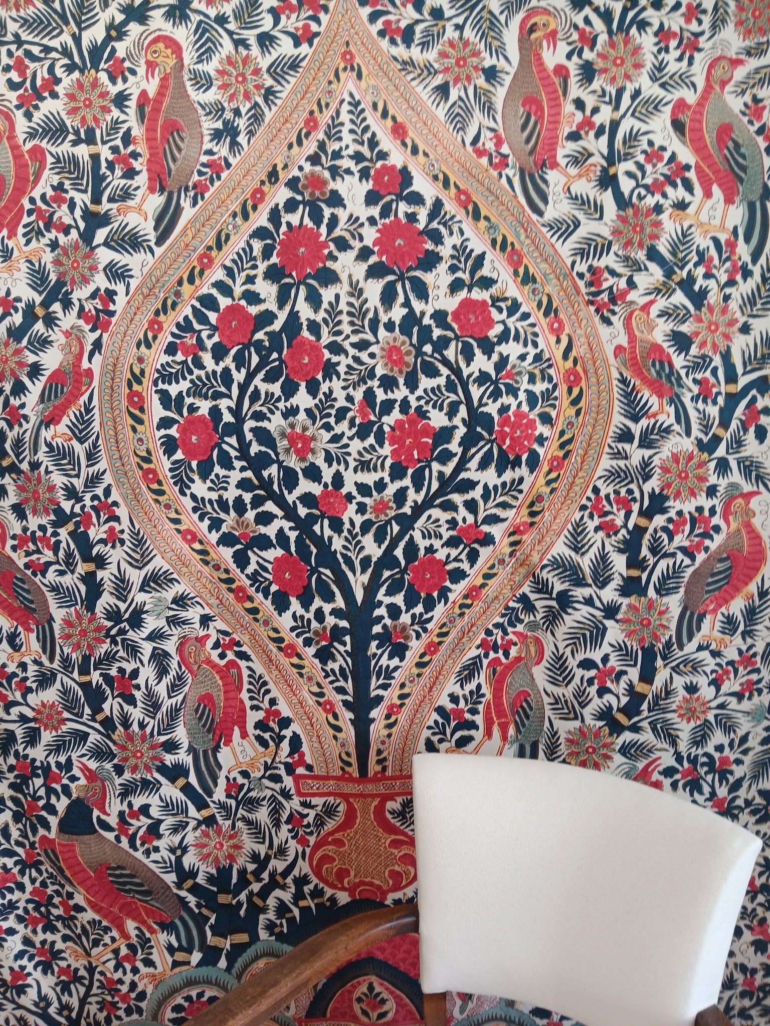 Détail de l’étoffe : fleurs rouges, oiseaux et feuillages sur fond clair